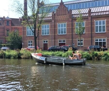 Two people in a sloop on an Amsterdam canal.