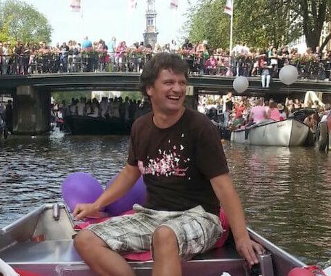 Man steers a boat during the Canal Parade in Amsterdam.